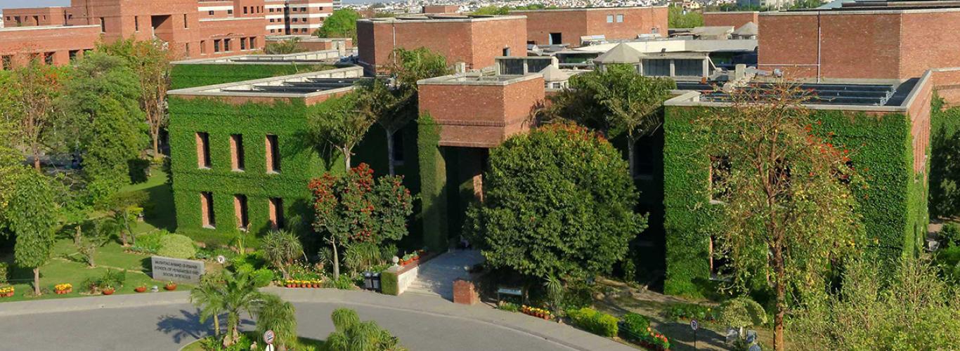 picture of LUMS academic block's red brick building covered with vines 